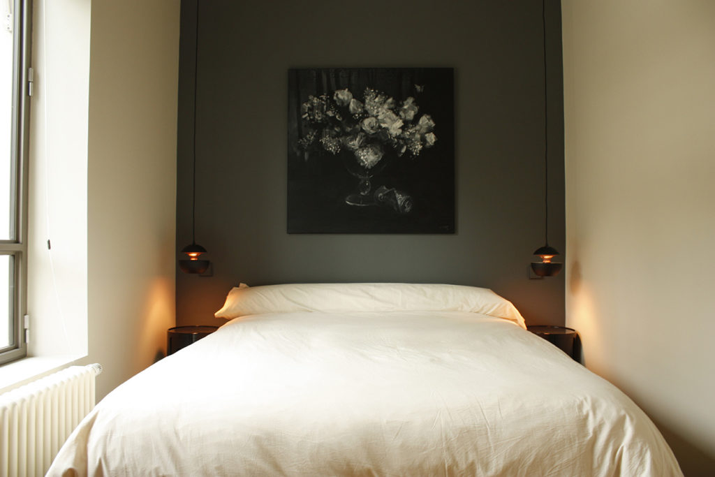 Une chambre avec deux suspensions pour lumière de chevet
