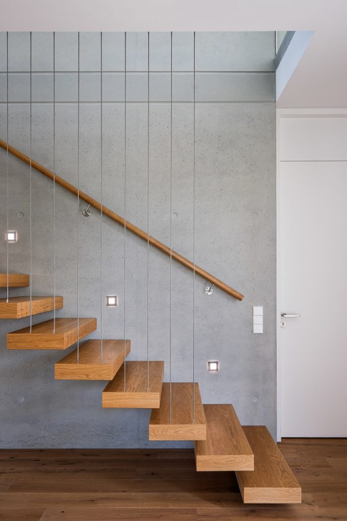 montée d'escalier lumineuse sur mur de béton brut