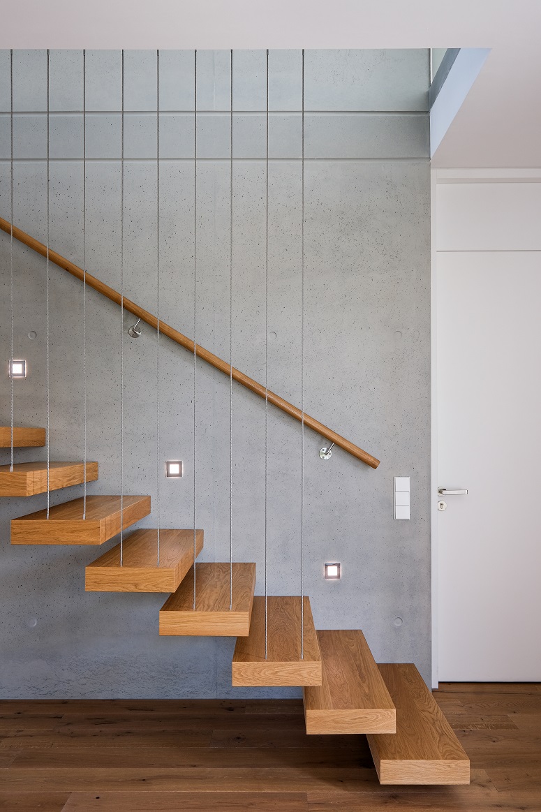 montée d'escalier lumineuse sur mur de béton brut