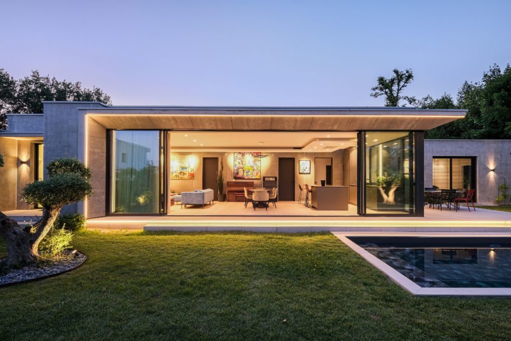 AC2R entreprise spécialisée en électricité à Lyon. Photo d'une maison vitrée éclairée dans l'ouest Lyonnais.