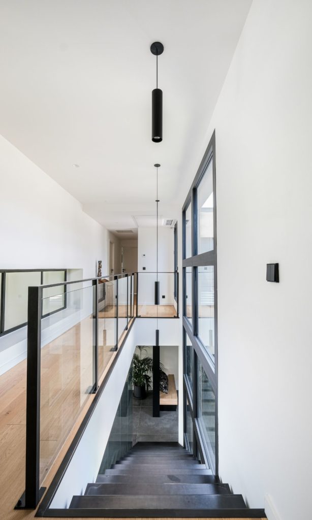 Couloir de l'étage avec un alignement propre des suspensions spots.