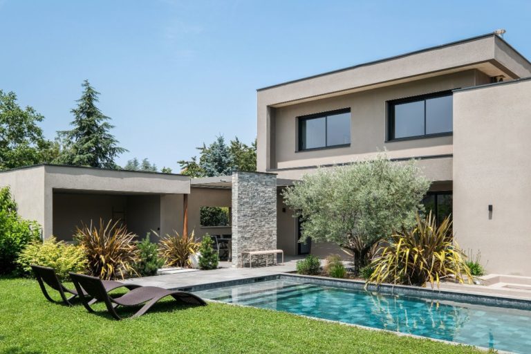 Maison moderne avec piscine de trois quart avec un ciel bleu