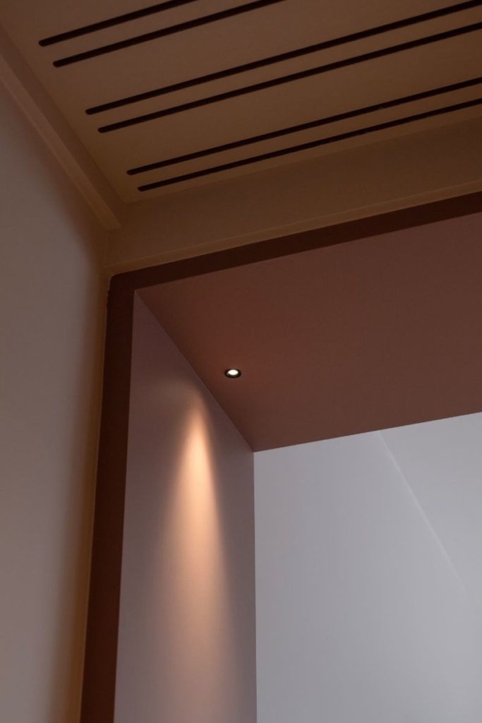 Mini spot encastré dans une structure en bois à l'entrée d'une chambre d'hôtel